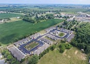 Thumbnail 22 of 23 - A bird's eye view of a residential area with a large green field and a roundabout in the center.