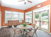 Thumbnail 23 of 23 - A patio with a table and chairs and a ceiling fan.