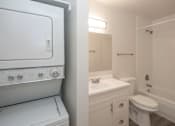Thumbnail 8 of 9 - A white oven and sink in a small bathroom.