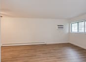 Thumbnail 5 of 9 - Empty room with wooden floor and white walls.