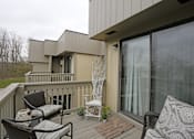 Thumbnail 9 of 9 - A balcony with a couch, chairs and a table.