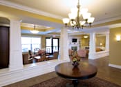 Thumbnail 7 of 18 - A large room with a table and chairs in the middle.