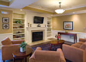 Thumbnail 13 of 18 - A living room with a fireplace and a television.