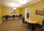 Thumbnail 18 of 18 - A conference room with a table, chairs, and a framed picture on the wall.