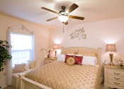 Thumbnail 15 of 18 - A bedroom with a bed, nightstands, and a ceiling fan.