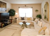 Thumbnail 8 of 18 - A living room with a white couch, a coffee table, and a television.