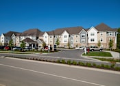 Thumbnail 3 of 18 - A row of houses with cars parked in front.
