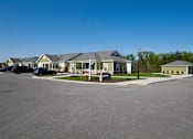 Thumbnail 6 of 18 - A parking lot with a building in the background.