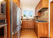 Thumbnail 13 of 18 - a kitchen with wooden cabinets and stainless steel appliances at 8535 Colgate-Fully Furnished Apartments, Los Angeles, California