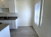 Thumbnail 10 of 23 - A kitchen with white cabinets and a black countertop.