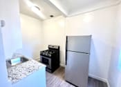 Thumbnail 13 of 23 - White kitchen featuring stainless steel refrigerator and stove