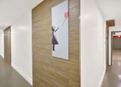 Thumbnail 32 of 34 - A hallway with a painting of a woman holding a balloon at Westwood Riviera Apartments, Los Angeles, CA, 90024