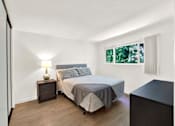 Thumbnail 10 of 34 - A bedroom with a bed, nightstand, and lamp at Westwood Riviera Apartments, Los Angeles, California