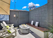 Thumbnail 3 of 34 - A patio with a hot tub, chairs, and a bench at Westwood Riviera Apartments, Los Angeles, California