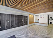 Thumbnail 12 of 34 - A long hallway with a row of mailboxes on the wall. at Westwood Riviera Apartments, California