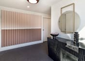 Thumbnail 1 of 18 - a hallway with a black dresser and a mirror and a door at 8535 Colgate-Fully Furnished Apartments, Los Angeles, CA