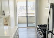 Thumbnail 7 of 21 - A kitchen with a stove and a sink.