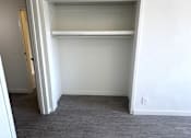 Thumbnail 17 of 23 - A white closet with a shelf and a door open.