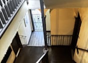 Thumbnail 2 of 23 - A staircase with a metal railing and wooden steps.