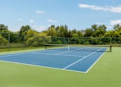 Thumbnail 7 of 21 - A tennis court with a net and no players.