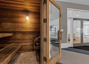 Thumbnail 6 of 21 - A room with a wooden bench and a glass door.