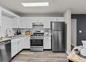 Thumbnail 12 of 21 - A modern kitchen with stainless steel appliances and white cabinets.