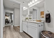 Thumbnail 16 of 21 - A bathroom with a marble countertop and a large mirror.