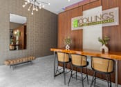 Thumbnail 4 of 15 - A conference room with a wooden table and chairs, a mirror, and a sign that reads "COLLINGS at the LUMBERYARD".