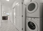 Thumbnail 15 of 15 - A laundry room with a washer and dryer stacked on top of each other.