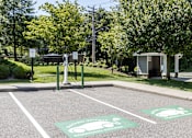 Thumbnail 11 of 19 - A parking lot with two electric vehicle charging stations.