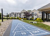 Thumbnail 9 of 24 - A blue shuffleboard court with the numbers 10 and off painted on it. at Merion Milford Apartment Homes, Milford, CT, 06460