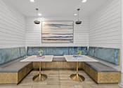 Thumbnail 5 of 23 - A modern dining area with a wooden table and blue cushioned booths.