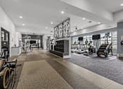 Thumbnail 21 of 23 - A gym with a variety of equipment including treadmills, stationary bikes, and weight machines.