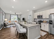 Thumbnail 9 of 23 - A modern kitchen with a large island and stainless steel appliances.