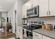 Thumbnail 10 of 23 - A modern kitchen with a stove, oven, and microwave.