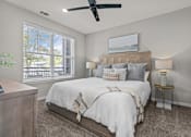 Thumbnail 14 of 23 - A bedroom with a large bed and a ceiling fan.