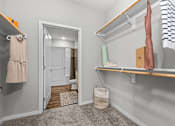 Thumbnail 17 of 23 - A small, clean, and organized bedroom with a closet and a mirror.