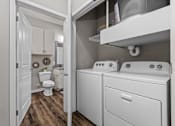 Thumbnail 16 of 23 - A white laundry room with a washer and dryer.