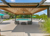 Thumbnail 34 of 35 - a patio with tables and umbrellas and a pool at The Austin Apartment Homes, New Jersey