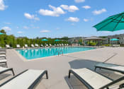Thumbnail 33 of 35 - the resort style pool is surrounded by lounge chairs and umbrellas at The Austin Apartment Homes, Deptford, New Jersey