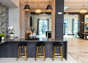 Thumbnail 10 of 20 - A bar area with three stools and a stone wall.
