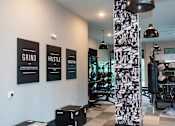 Thumbnail 12 of 20 - A gym with a wall of posters that say Grind, Hustle, and Elevate.