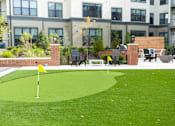 Thumbnail 15 of 20 - A small putting green in front of a building.