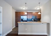 Thumbnail 9 of 16 - A kitchen with a wooden cabinet and a granite countertop. at Pennsauken Golf Course Villas, PENNSAUKEN, NJ, 08109