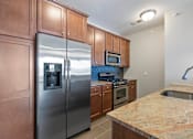 Thumbnail 12 of 16 - A kitchen with a granite counter top and stainless steel appliances. at Pennsauken Golf Course Villas, PENNSAUKEN, New Jersey