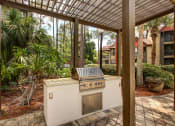 Thumbnail 8 of 34 - a covered patio with a gas grill at Timberwalk at Mandarin Apartment Homes, Florida, 32257