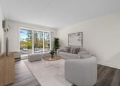 Thumbnail 2 of 8 - A living room with a grey sofa and a coffee table.