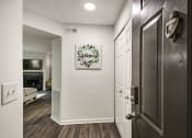 Thumbnail 17 of 34 - a hallway with a door and a living room with a fireplace at Timberwalk at Mandarin Apartment Homes, Florida, 32257