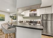 Thumbnail 19 of 34 - a kitchen with stainless steel appliances and a counter with chairs at Timberwalk at Mandarin Apartment Homes, Florida, 32257