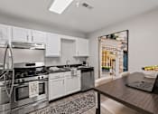 Thumbnail 15 of 21 - A modern kitchen with a stainless steel stove and white cabinets.